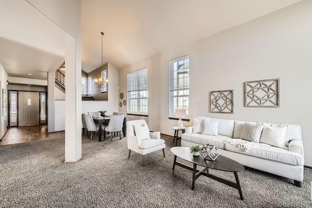 carpeted living room featuring a notable chandelier