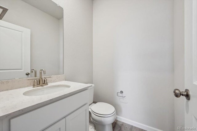 12353 E 101st Pl, Commerce City, CO 80022 - bathroom with vanity, toilet, baseboards, and wood finished floors