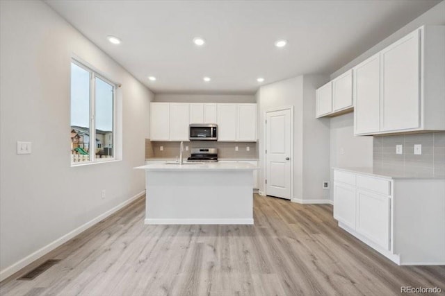 12353 E 101st Pl, Commerce City, CO 80022 - kitchen with visible vents, a sink, light countertops, tasteful backsplash, and appliances with stainless steel finishes