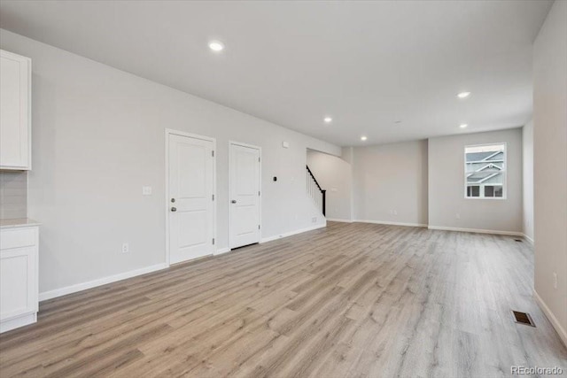 12353 E 101st Pl, Commerce City, CO 80022 - unfurnished living room featuring recessed lighting, stairway, and light wood-type flooring