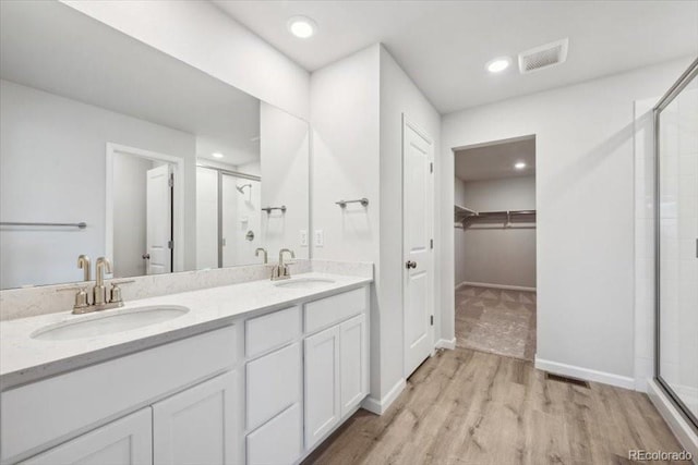 12353 E 101st Pl, Commerce City, CO 80022 - full bathroom featuring a sink, a stall shower, visible vents, and wood finished floors