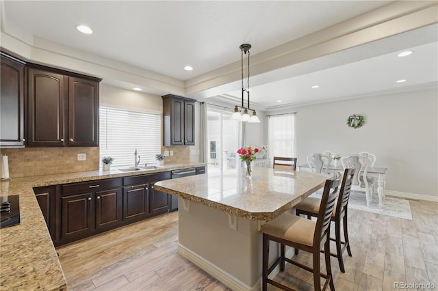 1673 Morningview Ln, Castle Rock, CO 80109 - kitchen with a breakfast bar, a sink, dark brown cabinets, light countertops, and recessed lighting