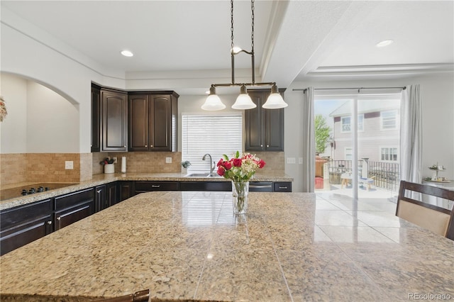1673 Morningview Ln, Castle Rock, CO 80109 - kitchen with decorative backsplash, a sink, black electric cooktop, dark brown cabinets, and hanging light fixtures