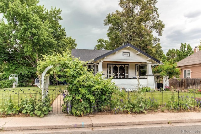 bungalow-style house featuring a fenced front yard, a front yard, and a gate