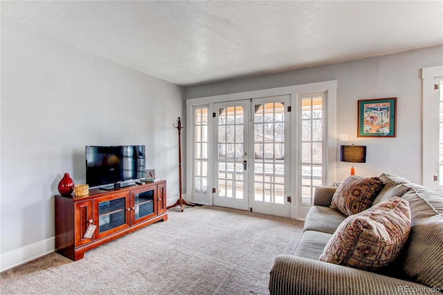 living room featuring french doors, light colored carpet, and baseboards