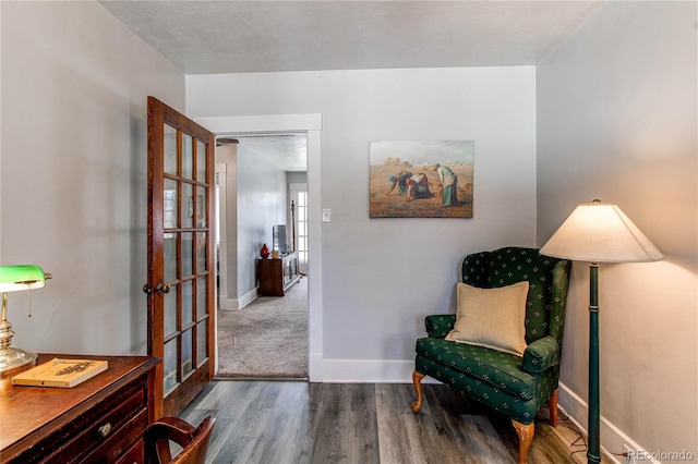 sitting room featuring baseboards and wood finished floors