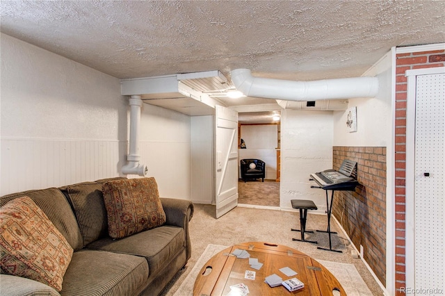 living area featuring light carpet, wainscoting, and a textured ceiling