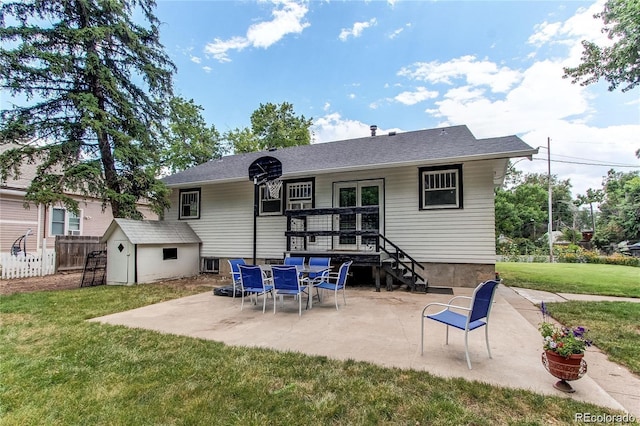 rear view of property featuring a patio area, a yard, an outdoor structure, and fence