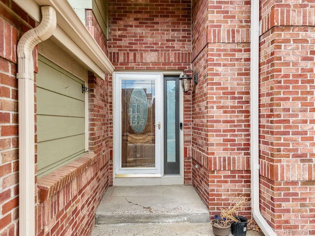 property entrance featuring brick siding