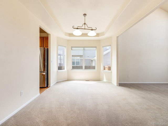 unfurnished room with light carpet, baseboards, and a tray ceiling