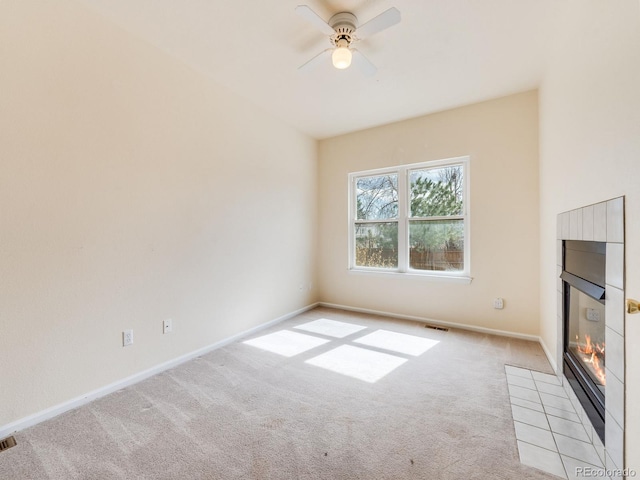 unfurnished living room with visible vents, baseboards, light colored carpet, a fireplace with flush hearth, and ceiling fan