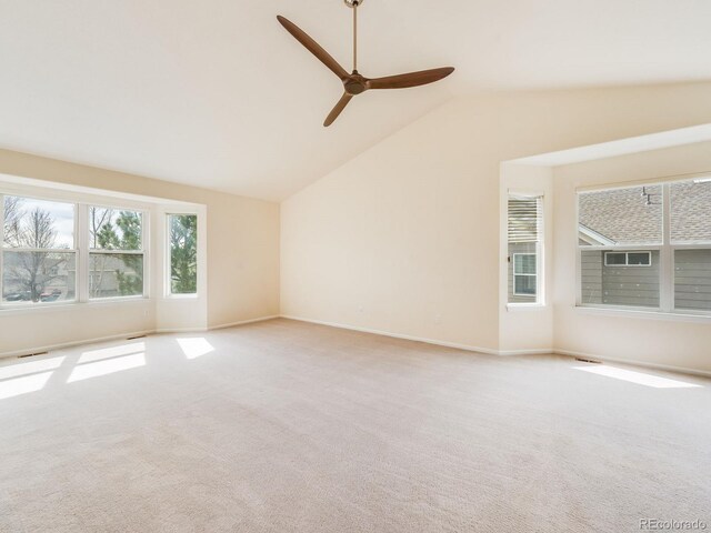 carpeted empty room featuring lofted ceiling, ceiling fan, and baseboards