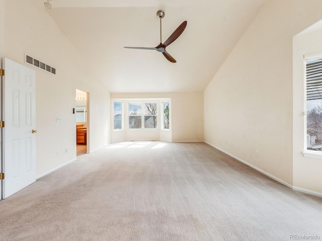 spare room featuring high vaulted ceiling, carpet flooring, and visible vents