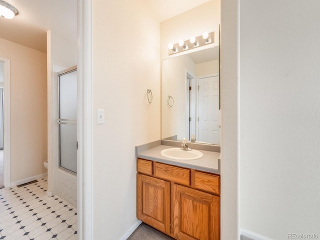 full bathroom with toilet, vanity, baseboards, and tile patterned floors