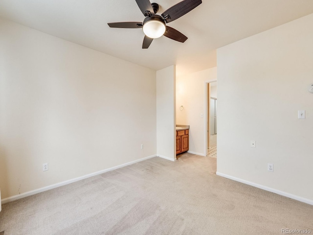 unfurnished bedroom featuring light carpet, ceiling fan, ensuite bath, and baseboards