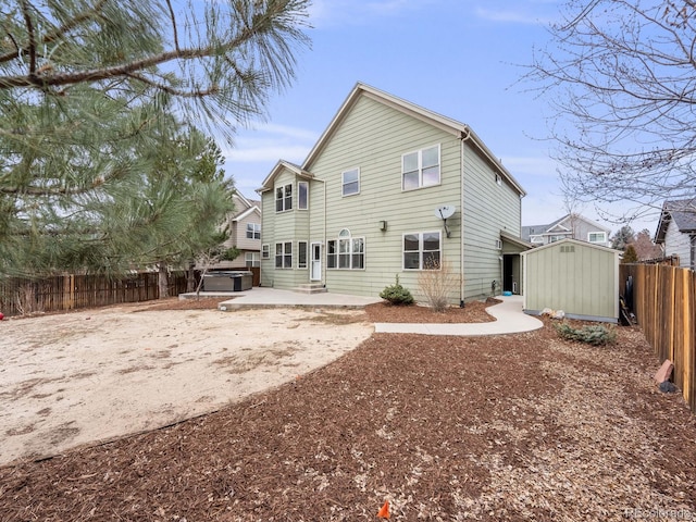 rear view of house with a storage shed, a patio, an outdoor structure, and a fenced backyard