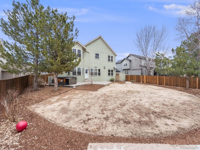 rear view of property featuring a patio area and a fenced backyard