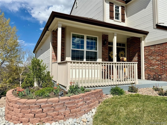 view of home's exterior featuring brick siding and covered porch