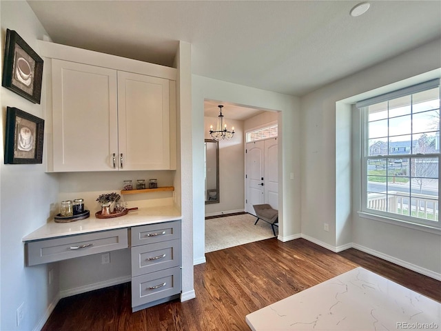 office with a chandelier, baseboards, and dark wood-style flooring