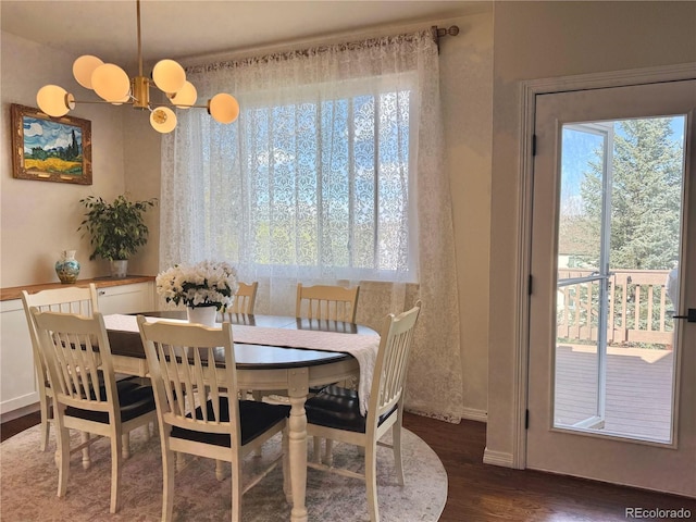 dining area with plenty of natural light, baseboards, a chandelier, and dark wood-style flooring