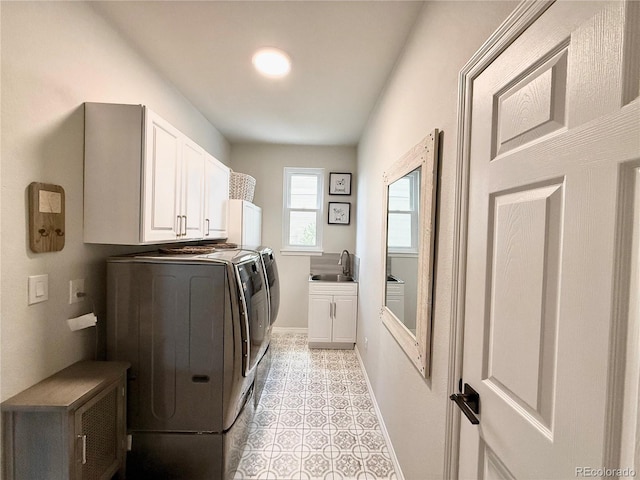 laundry area with washing machine and dryer, baseboards, cabinet space, and a sink