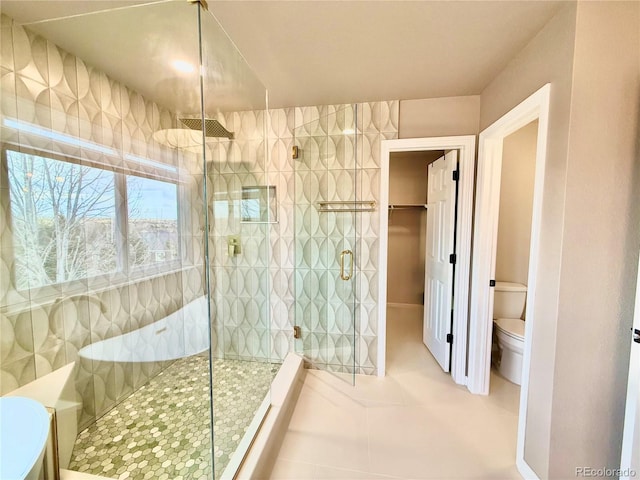 bathroom with tile patterned floors, toilet, and a walk in shower