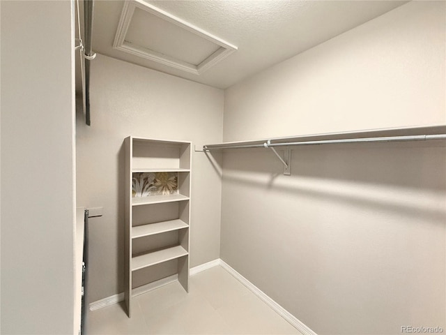 spacious closet featuring attic access