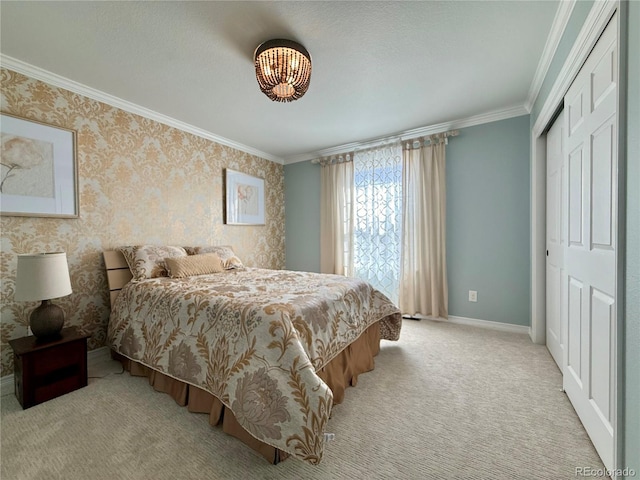 carpeted bedroom with a chandelier, baseboards, a closet, and crown molding