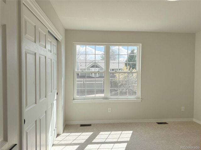 interior space featuring light carpet, visible vents, and baseboards