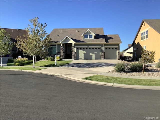 craftsman-style house featuring a garage, stone siding, a front lawn, and driveway