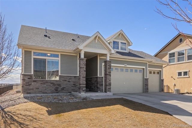 view of front facade featuring stone siding, concrete driveway, roof with shingles, and an attached garage