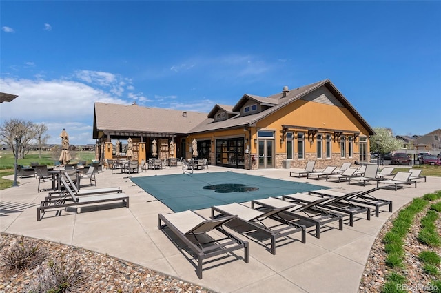 community pool with a patio area and fence