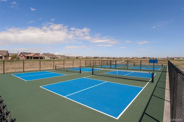 view of tennis court with community basketball court, a residential view, and fence