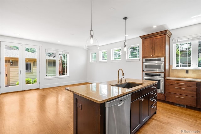 1934 S Sherman St, Denver, CO 80210 - kitchen featuring stainless steel appliances, decorative light fixtures, light wood-style flooring, recessed lighting, and light stone countertops