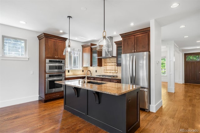 1934 S Sherman St, Denver, CO 80210 - kitchen with stainless steel appliances, tasteful backsplash, dark wood finished floors, a center island with sink, and recessed lighting