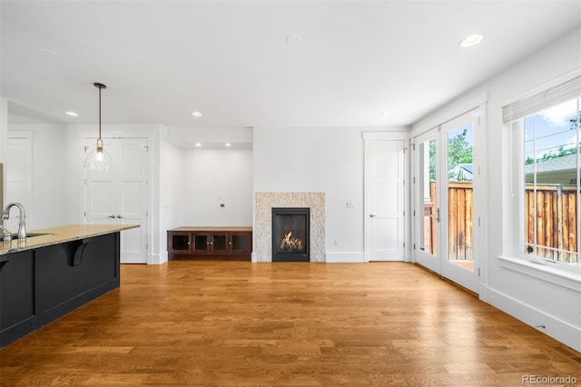 1934 S Sherman St, Denver, CO 80210 - unfurnished living room with wood finished floors, recessed lighting, and a warm lit fireplace