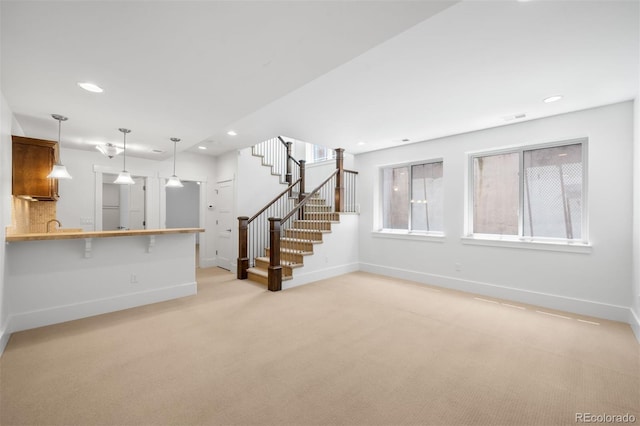 1934 S Sherman St, Denver, CO 80210 - unfurnished living room with light colored carpet, stairway, and recessed lighting