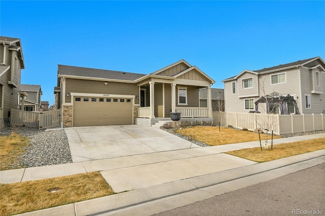 craftsman house featuring board and batten siding, fence, covered porch, a garage, and driveway