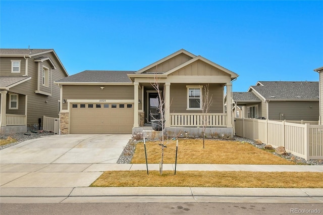 view of front facade with a porch, fence, board and batten siding, concrete driveway, and an attached garage