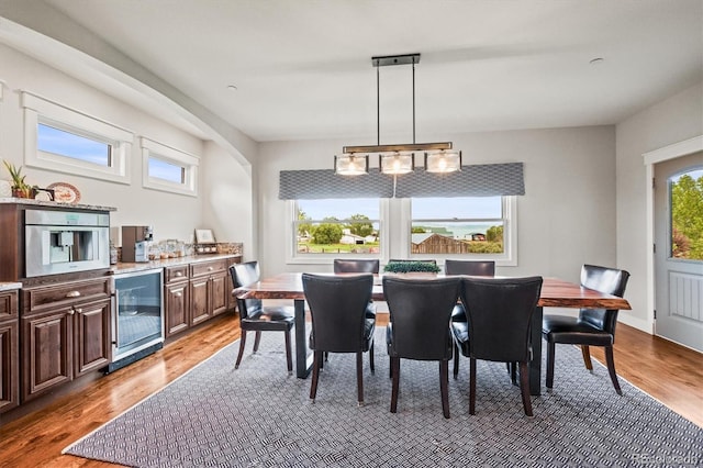 6331 County Road 32, Platteville, CO 80651 - dining area featuring wine cooler, wood finished floors, and arched walkways