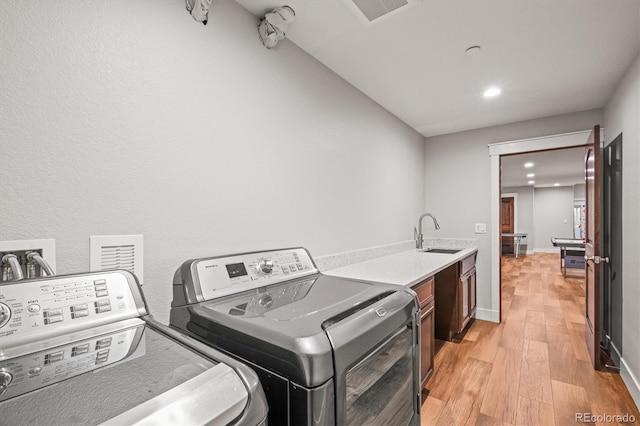 6331 County Road 32, Platteville, CO 80651 - laundry area featuring washer and clothes dryer, light wood-type flooring, recessed lighting, and cabinet space