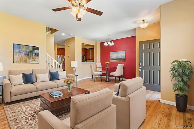 1284 Timber Run Hts, Monument, CO 80132 - living area with light wood-style floors, a ceiling fan, a chandelier, and stairs