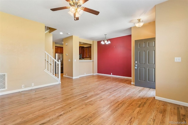1284 Timber Run Hts, Monument, CO 80132 - unfurnished living room with a chandelier, light wood-style floors, a ceiling fan, and stairway