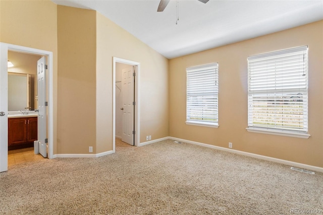 1284 Timber Run Hts, Monument, CO 80132 - unfurnished bedroom with light colored carpet, vaulted ceiling, a walk in closet, ensuite bath, and a ceiling fan