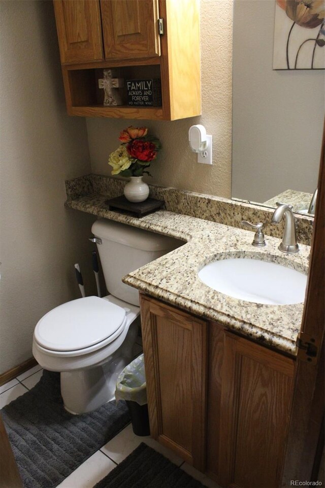 half bath with tile patterned flooring, toilet, and vanity