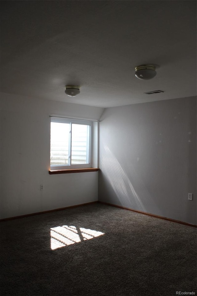 carpeted spare room with visible vents and baseboards