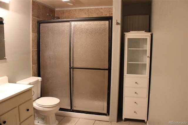 bathroom with vanity, toilet, a shower stall, and tile patterned flooring