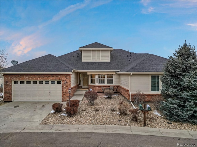 view of front of property featuring brick siding, roof with shingles, concrete driveway, and an attached garage