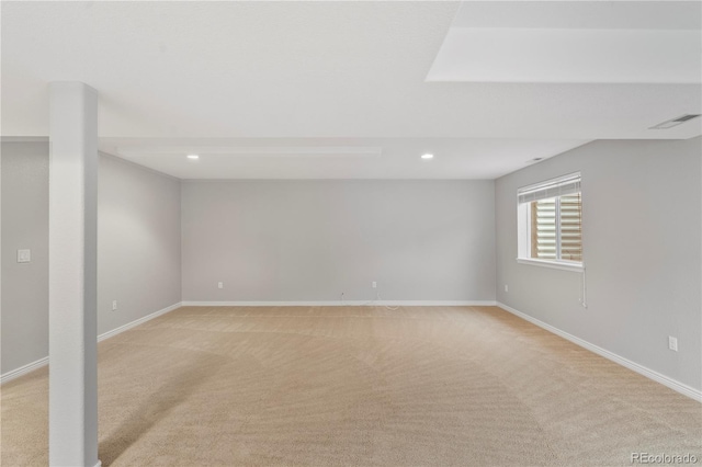 below grade area with visible vents, light carpet, and baseboards