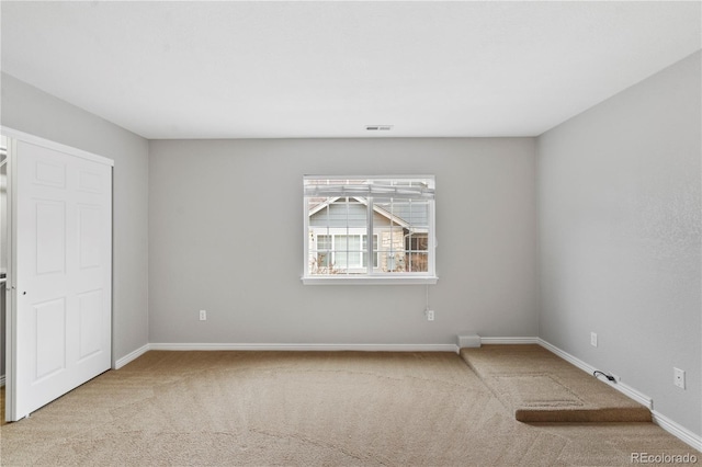 carpeted spare room with baseboards and visible vents